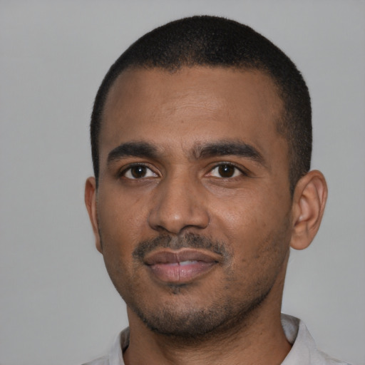 Joyful black young-adult male with short  black hair and brown eyes