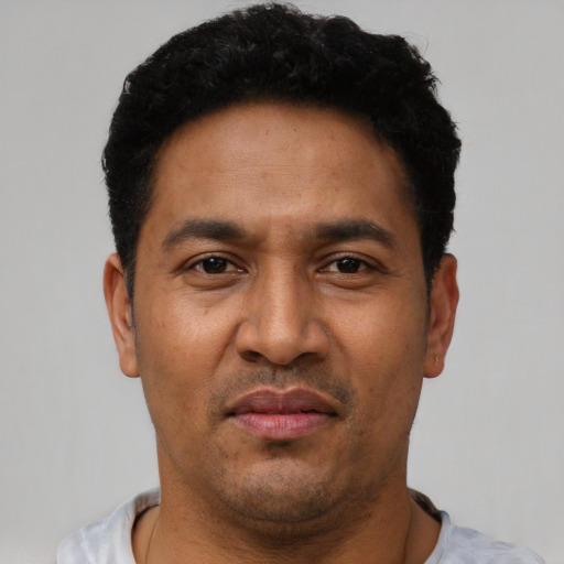Joyful latino adult male with short  black hair and brown eyes
