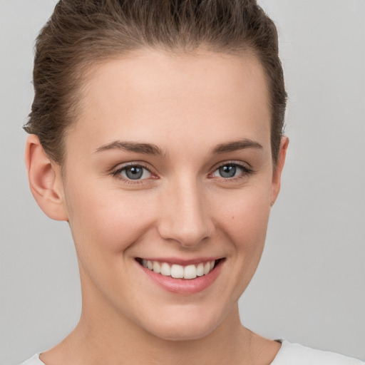 Joyful white young-adult female with short  brown hair and grey eyes