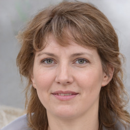 Joyful white adult female with medium  brown hair and grey eyes