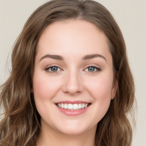 Joyful white young-adult female with long  brown hair and green eyes