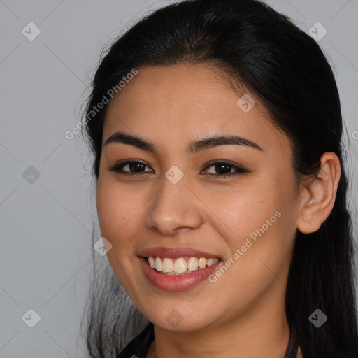 Joyful latino young-adult female with long  brown hair and brown eyes