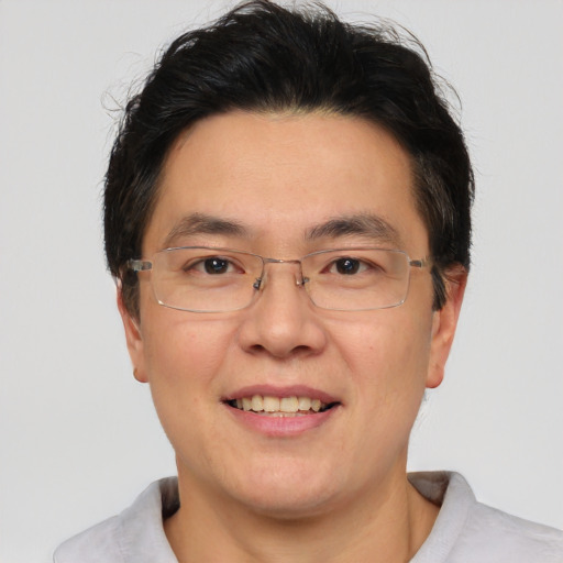 Joyful asian adult male with short  brown hair and brown eyes