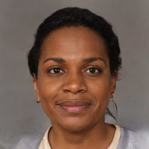 Joyful black adult female with short  black hair and brown eyes