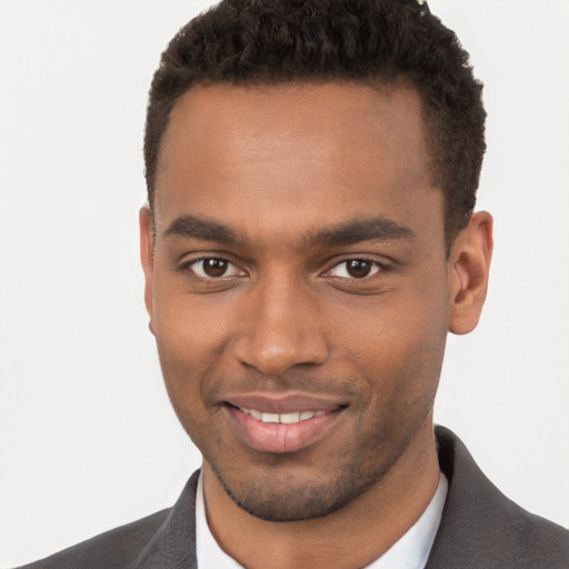 Joyful black young-adult male with short  brown hair and brown eyes