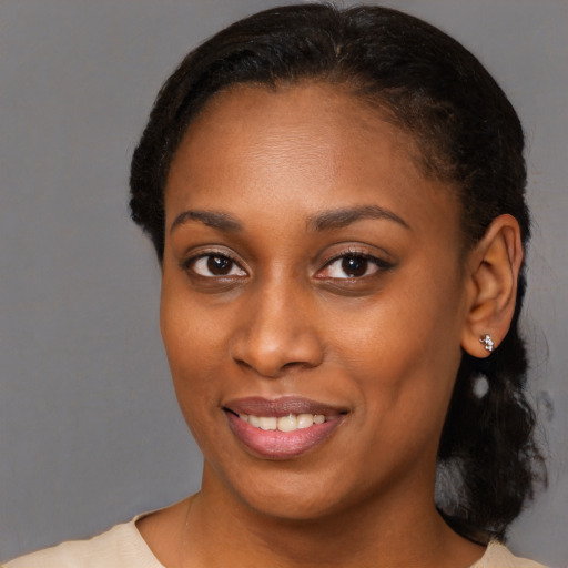 Joyful black young-adult female with short  black hair and brown eyes