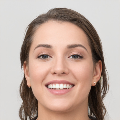 Joyful white young-adult female with long  brown hair and grey eyes