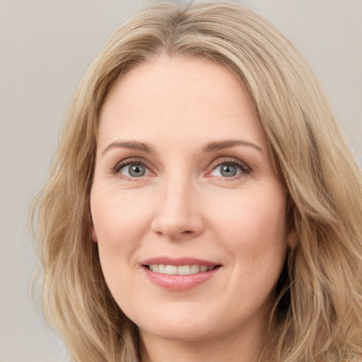 Joyful white adult female with long  brown hair and green eyes