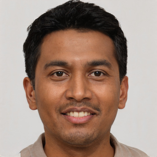Joyful latino young-adult male with short  black hair and brown eyes