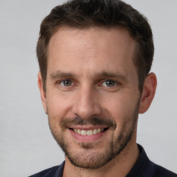 Joyful white adult male with short  brown hair and brown eyes