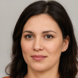 Joyful white adult female with long  brown hair and brown eyes