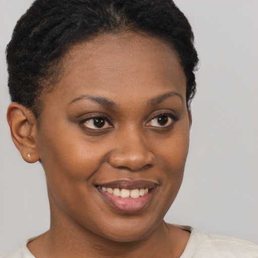 Joyful black young-adult female with short  brown hair and brown eyes