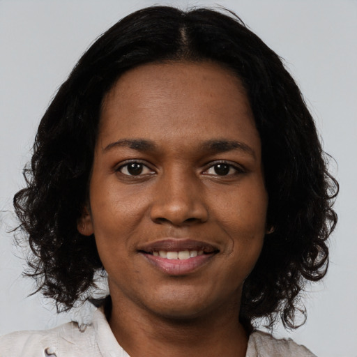 Joyful black young-adult female with medium  black hair and brown eyes