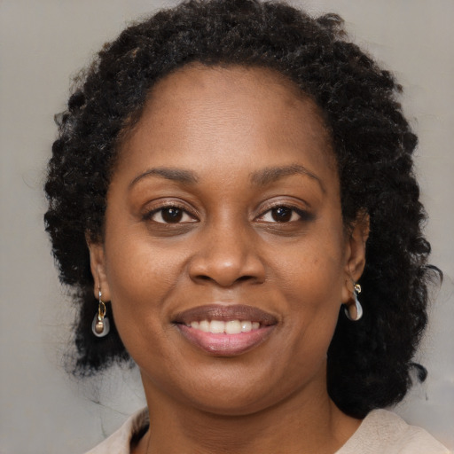 Joyful black adult female with medium  brown hair and brown eyes