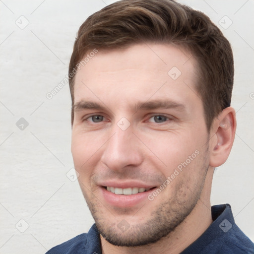 Joyful white young-adult male with short  brown hair and grey eyes