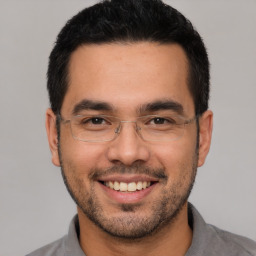 Joyful white young-adult male with short  black hair and brown eyes