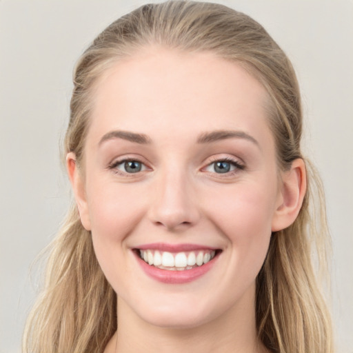 Joyful white young-adult female with long  brown hair and blue eyes