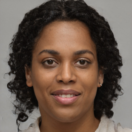 Joyful black young-adult female with medium  brown hair and brown eyes