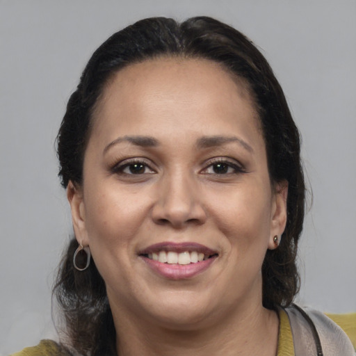 Joyful latino adult female with medium  brown hair and brown eyes