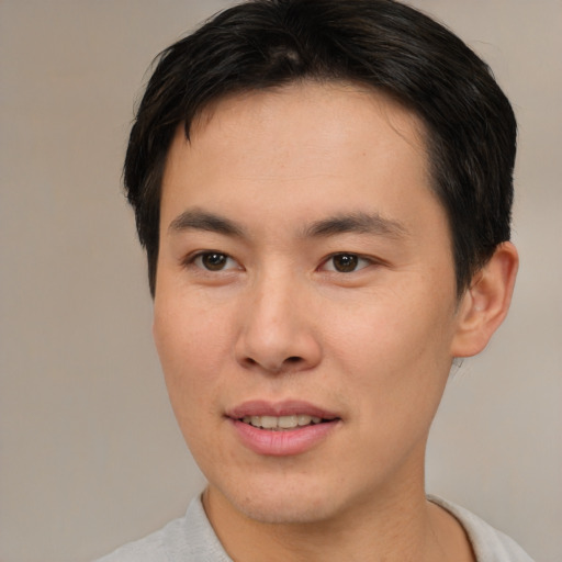 Joyful asian young-adult male with short  brown hair and brown eyes