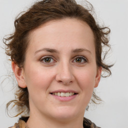 Joyful white young-adult female with medium  brown hair and green eyes