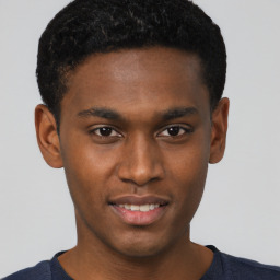 Joyful black young-adult male with short  brown hair and brown eyes