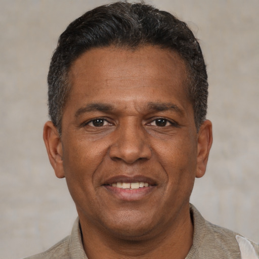 Joyful black adult male with short  brown hair and brown eyes