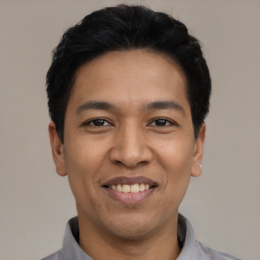 Joyful latino adult male with short  black hair and brown eyes