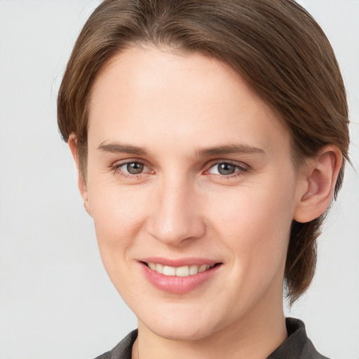 Joyful white young-adult female with short  brown hair and grey eyes