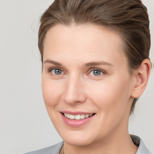 Joyful white young-adult female with short  brown hair and grey eyes