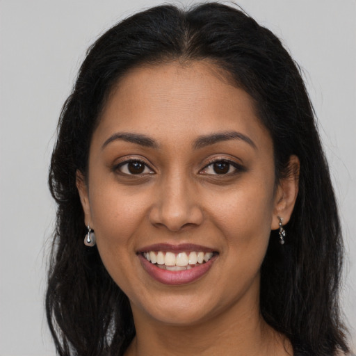 Joyful latino young-adult female with long  brown hair and brown eyes