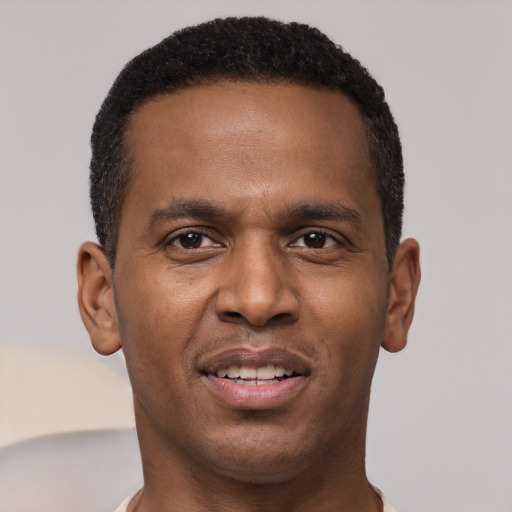 Joyful black young-adult male with short  brown hair and brown eyes