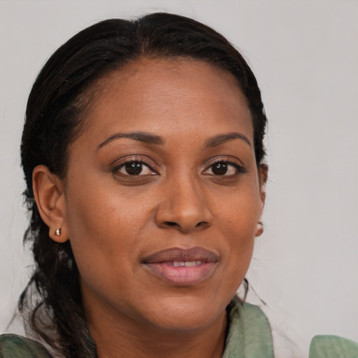 Joyful black young-adult female with long  brown hair and brown eyes