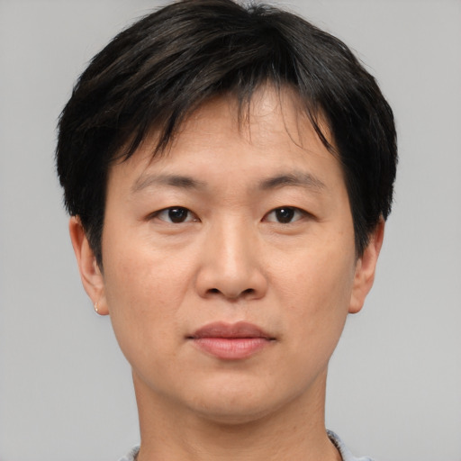 Joyful asian adult male with short  brown hair and brown eyes