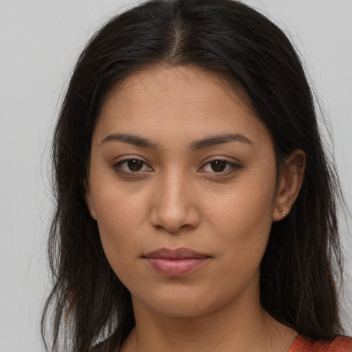 Joyful latino young-adult female with long  brown hair and brown eyes