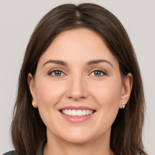 Joyful white young-adult female with long  brown hair and grey eyes