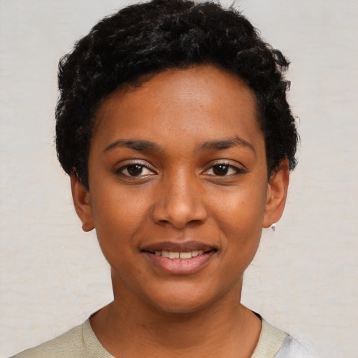 Joyful black young-adult female with short  black hair and brown eyes