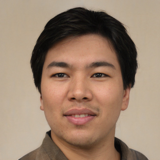 Joyful asian young-adult male with short  black hair and brown eyes