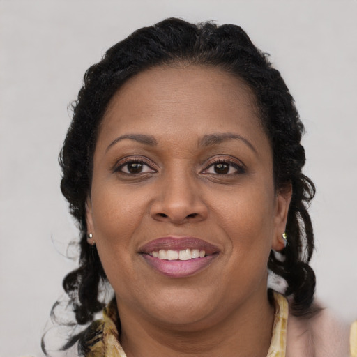 Joyful black young-adult female with long  brown hair and brown eyes