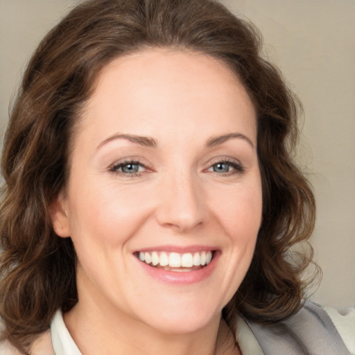 Joyful white young-adult female with medium  brown hair and green eyes