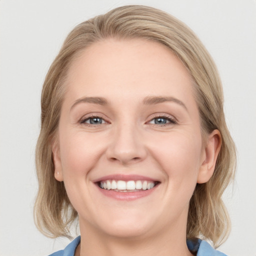 Joyful white young-adult female with medium  brown hair and blue eyes