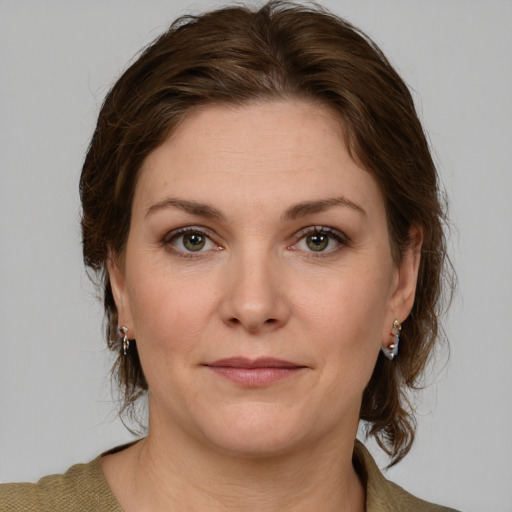 Joyful white young-adult female with medium  brown hair and green eyes