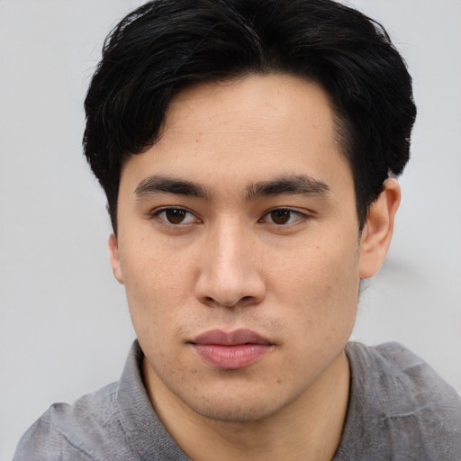 Joyful asian young-adult male with short  brown hair and brown eyes