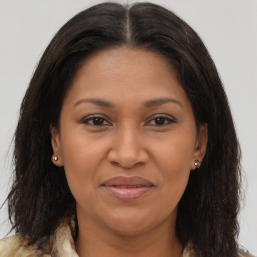Joyful black adult female with long  brown hair and brown eyes