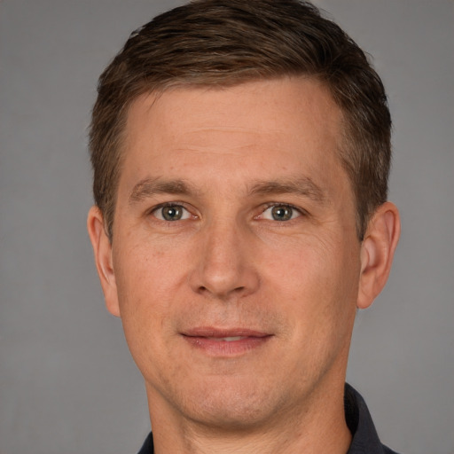 Joyful white adult male with short  brown hair and grey eyes