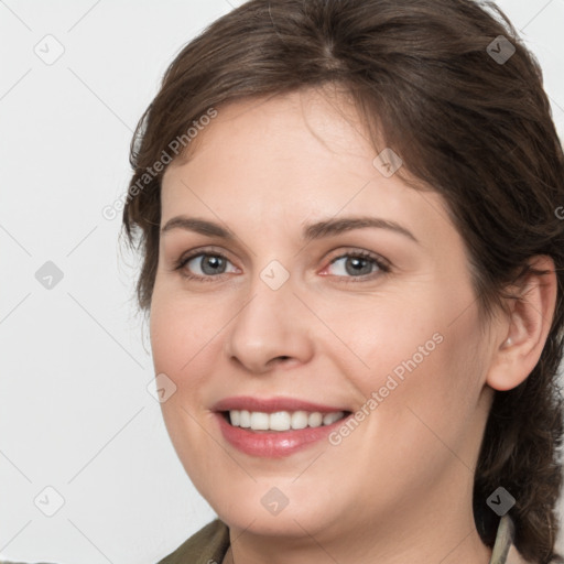 Joyful white young-adult female with medium  brown hair and grey eyes