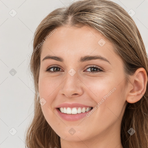 Joyful white young-adult female with long  brown hair and blue eyes