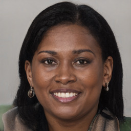 Joyful black young-adult female with long  brown hair and brown eyes