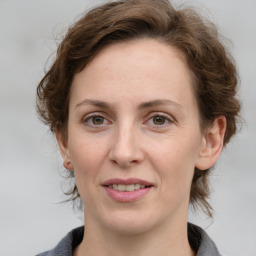 Joyful white adult female with medium  brown hair and grey eyes