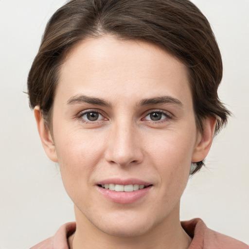 Joyful white young-adult female with short  brown hair and grey eyes